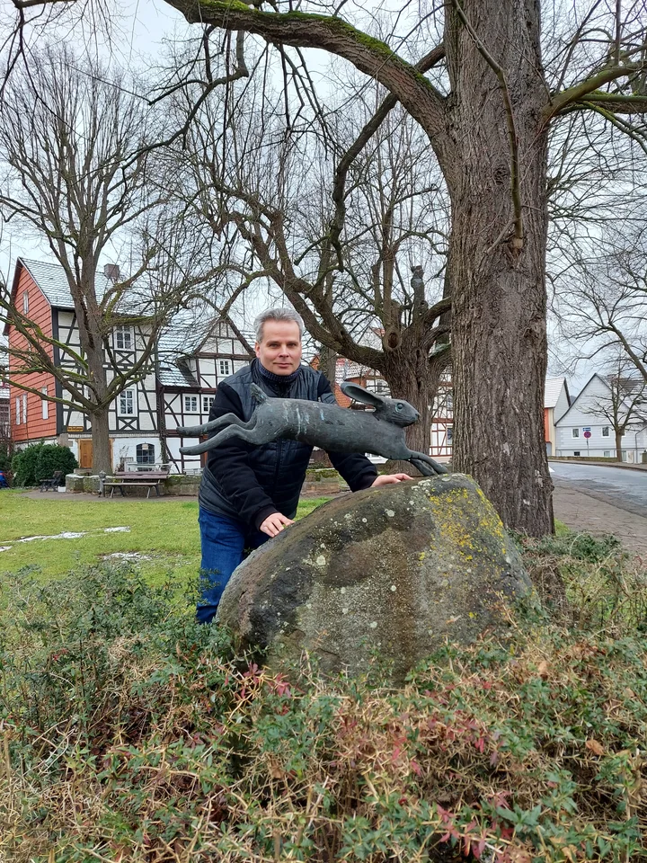 Torsten Schönberg neben der Hasenskulptur am Anger in Grebendorf.